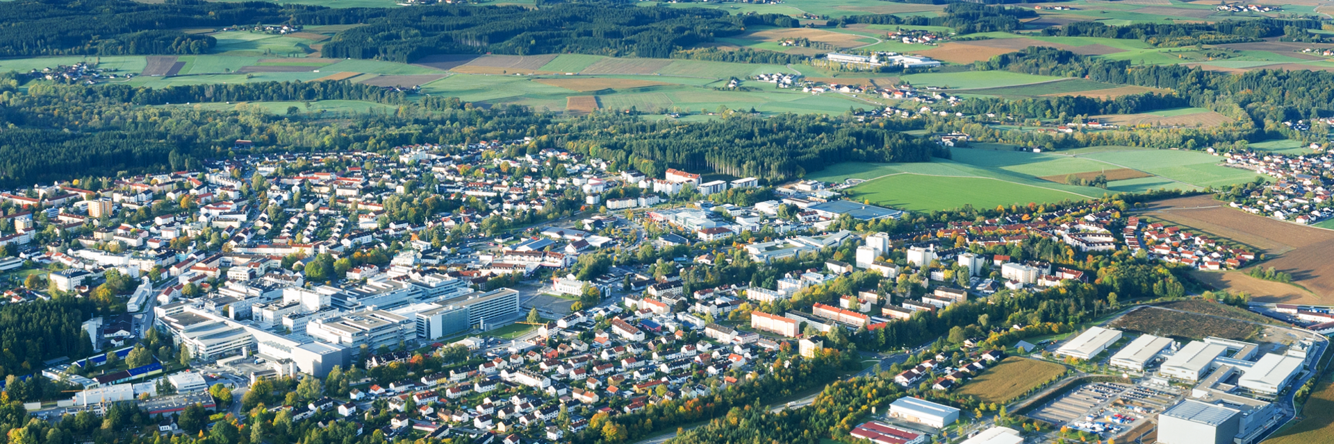 Standort Traunreut aus der Luft Weitläufige Luftaufnahme des Firmengeländes und der umliegenden Stadt Traunreut