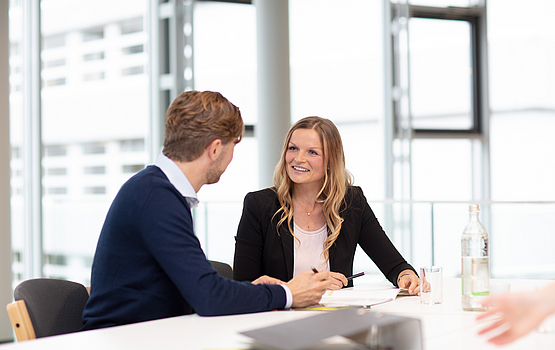 Gespräch im Bewerbungsprozess Personen sitzen an einem Tisch und führen ein formelles Gespräch