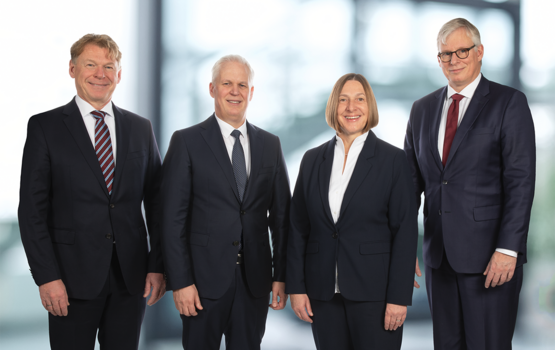 Geschäftsführung des Unternehmens Geschäftsführung steht gemeinsam in formeller Unternehmensumgebung